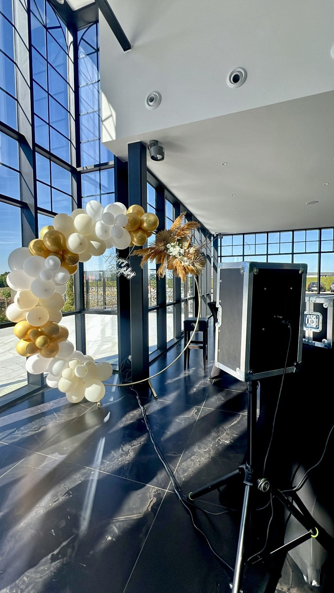Arche de ballons dorés et photobooth installés pour un anniversaire